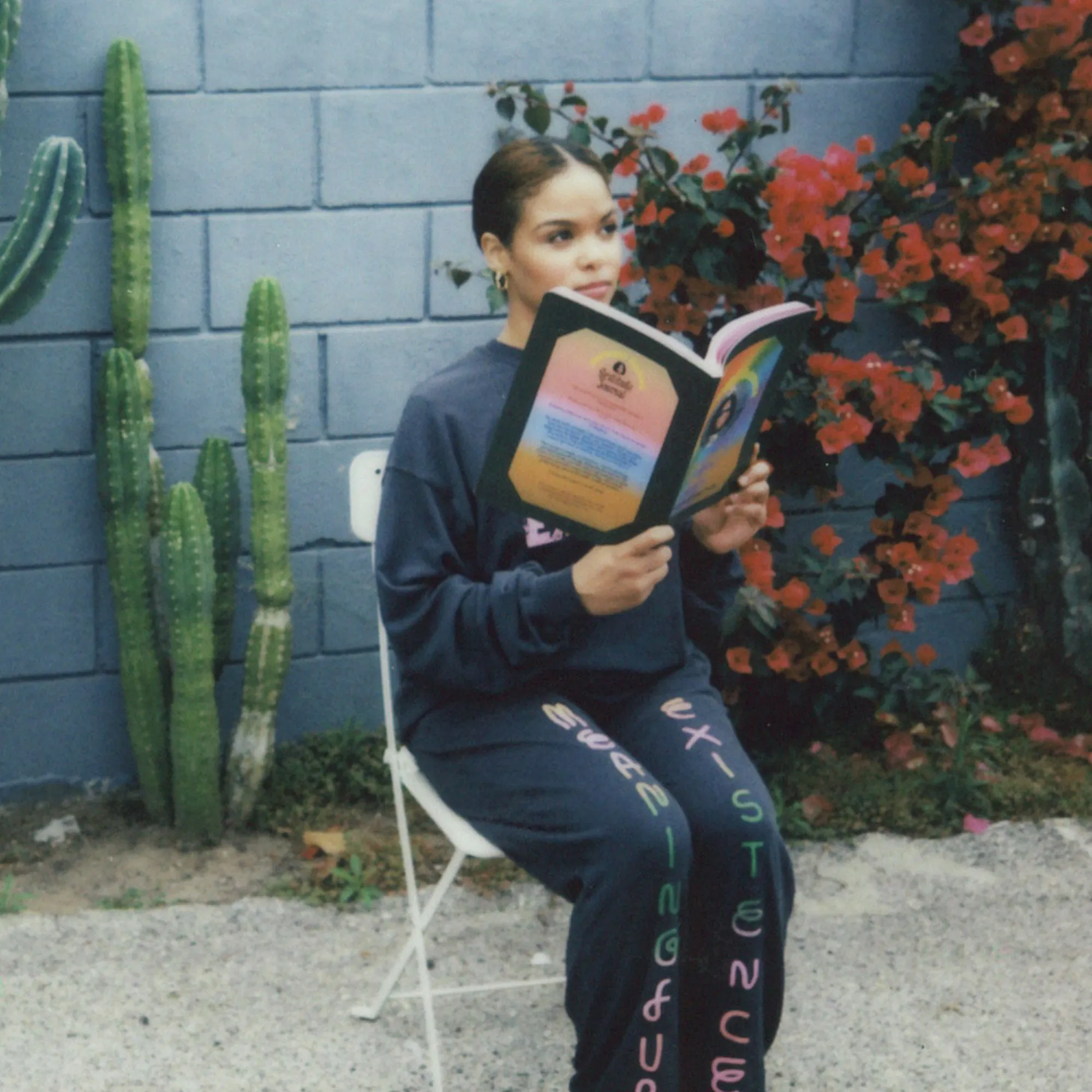 A woman sits on a chair reading the Gratitude Journal